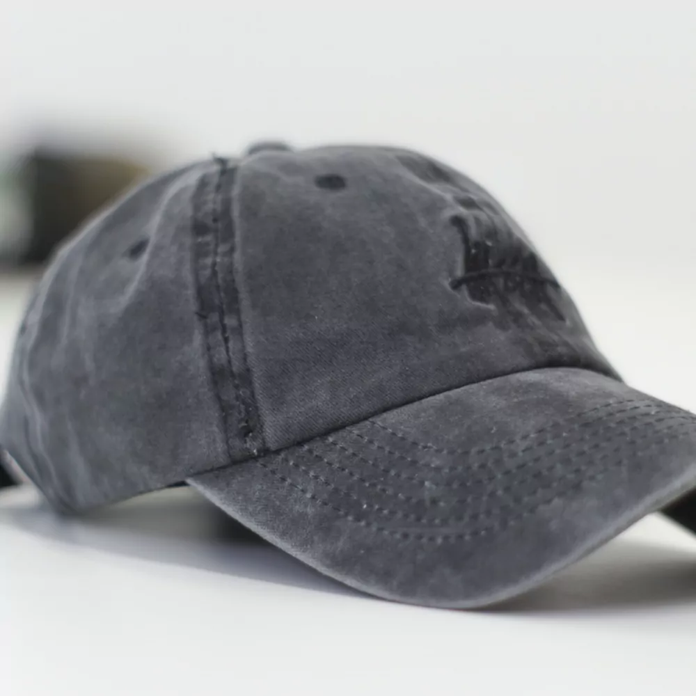 A washed grey dad hat on a white table
