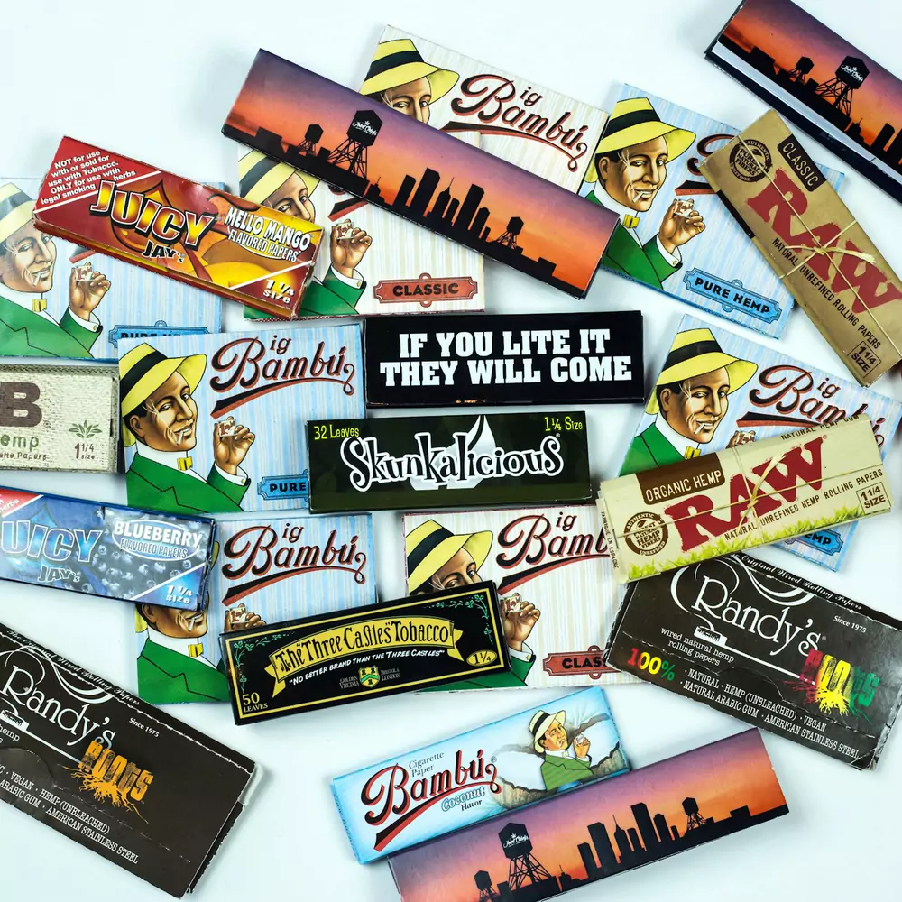 Packs of rolling papers from several brands spread out on a white table