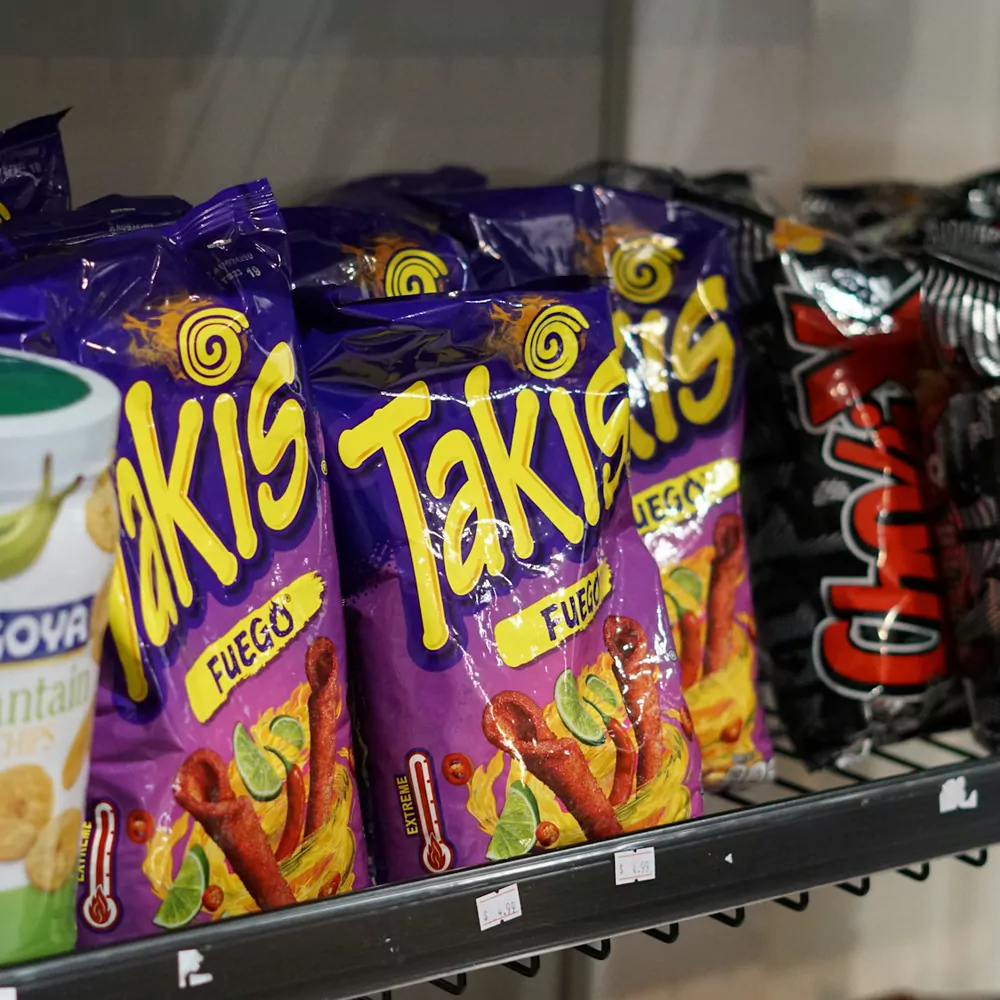 Bags of Takis Fuego rolled tortilla chips on a shop shelf